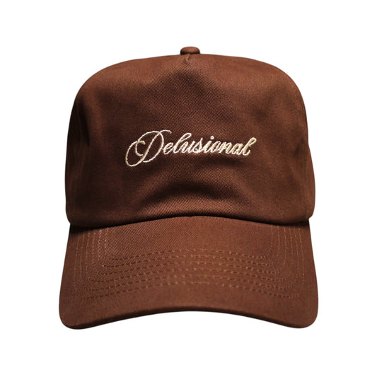 A brown baseball cap with 'Delusional' embroidered in white script across the front, shown against a plain white background.