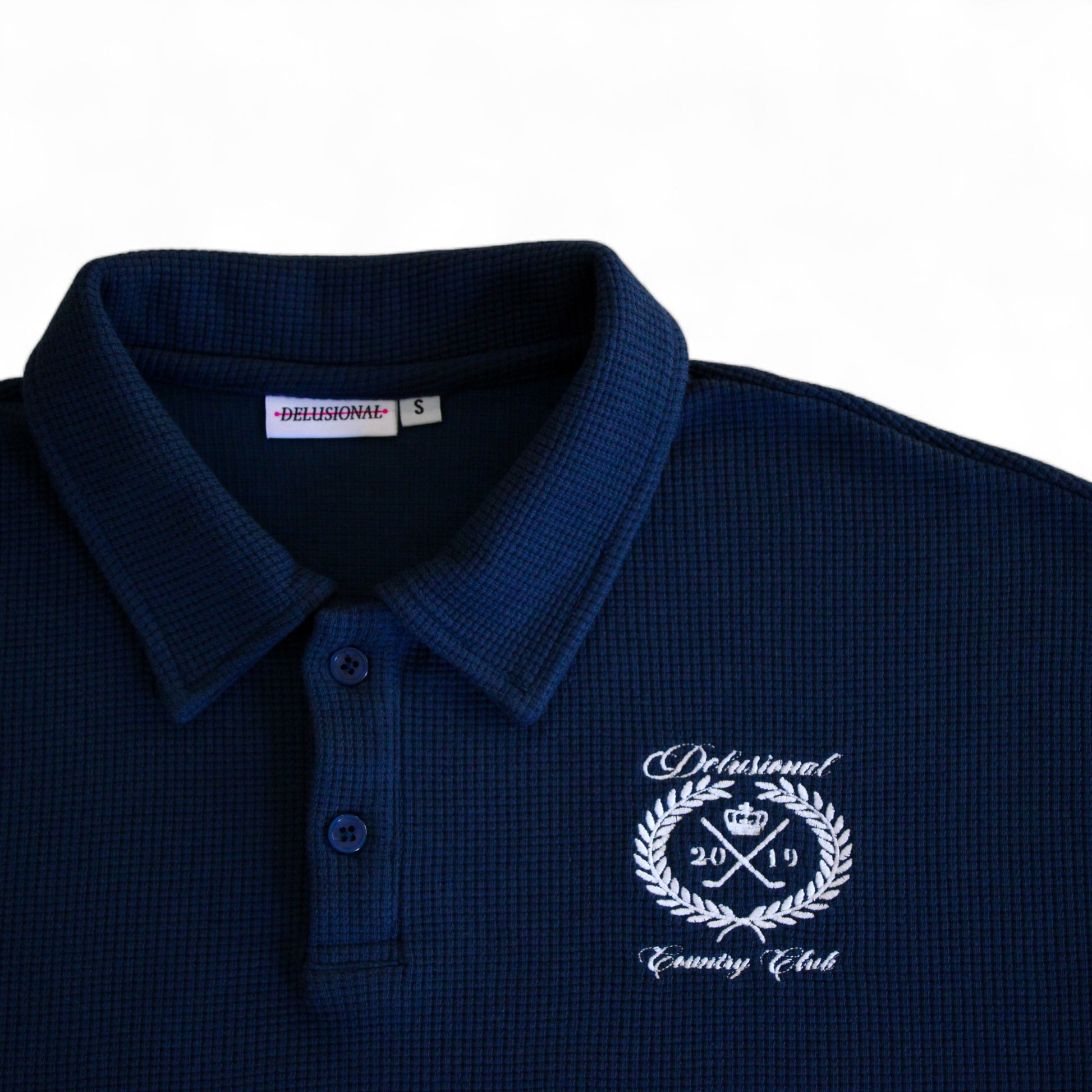 Embroidered artwork detail on men's cotton waffle polo